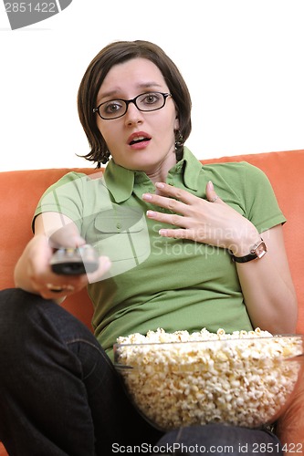 Image of young woman eat popcorn and watching tv