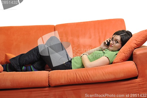 Image of happy young woman relax on orange sofa