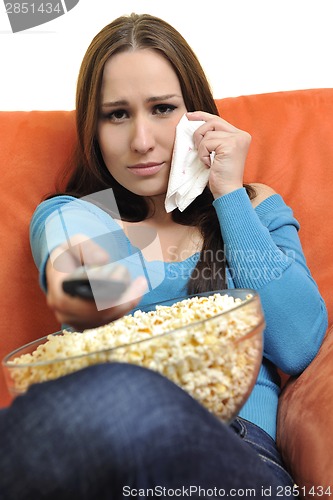 Image of young woman eat popcorn and watching tv