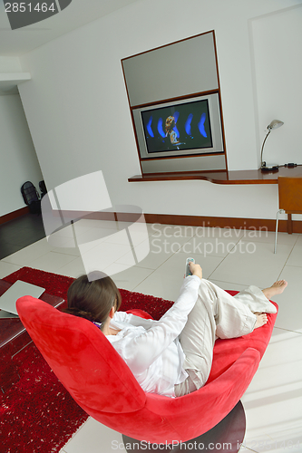 Image of young woman watching tv at home