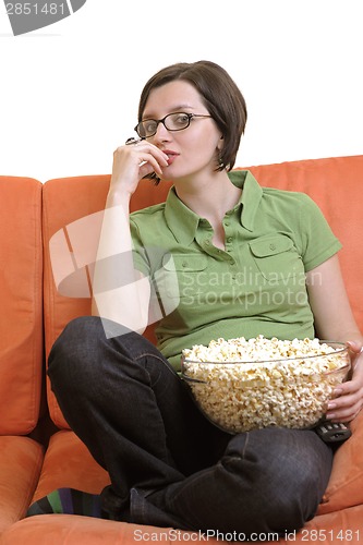 Image of young woman eat popcorn and watching tv