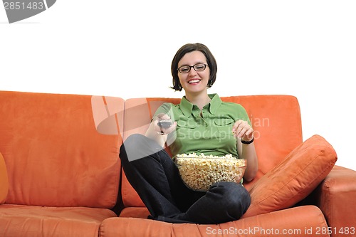 Image of young woman eat popcorn and watching tv