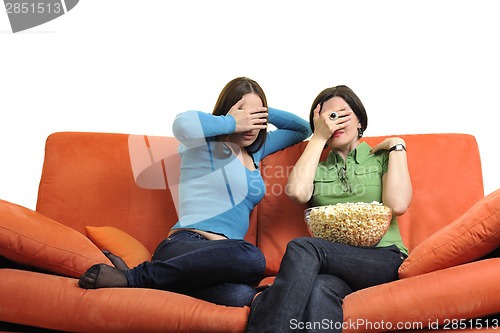 Image of female friends eating popcorn and watching tv at home