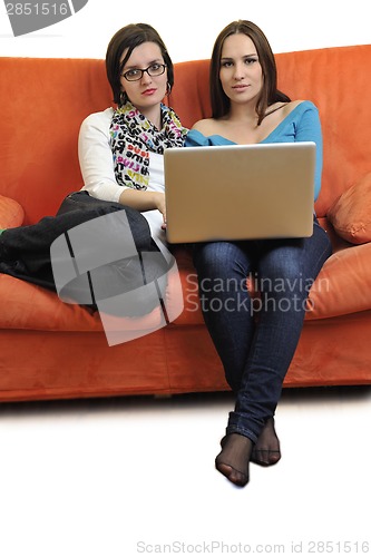 Image of female friends working on laptop computer at home