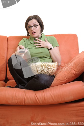 Image of young woman eat popcorn and watching tv