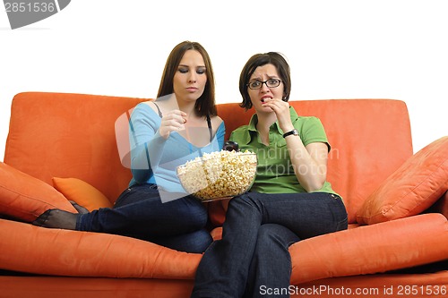 Image of female friends eating popcorn and watching tv at home