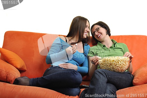 Image of female friends eating popcorn and watching tv at home