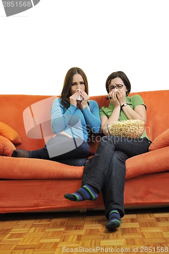 Image of female friends eating popcorn and watching tv at home