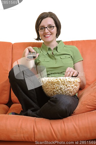 Image of young woman eat popcorn and watching tv