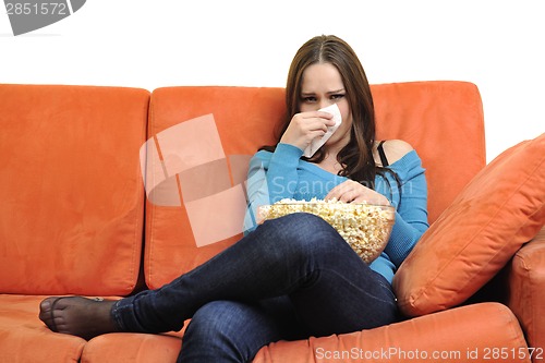 Image of young woman eat popcorn and watching tv