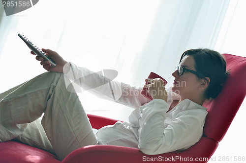 Image of young woman watching tv at home