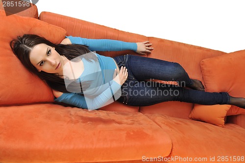 Image of happy young woman relax on orange sofa