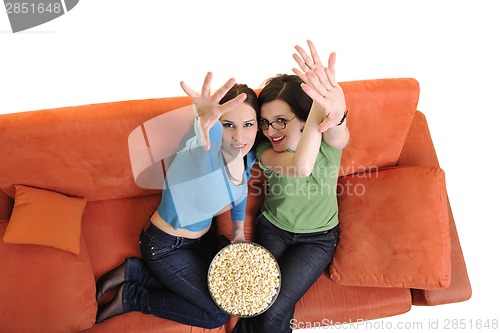 Image of female friends eating popcorn and watching tv at home