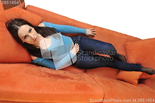 Image of happy young woman relax on orange sofa