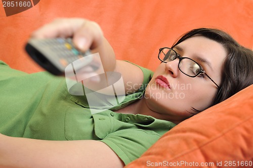 Image of happy young woman relax on orange sofa