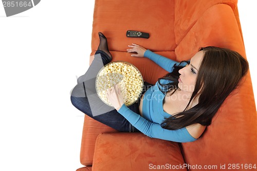 Image of young woman eat popcorn and watching tv