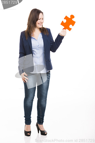 Image of Business woman holding a puzzle piece