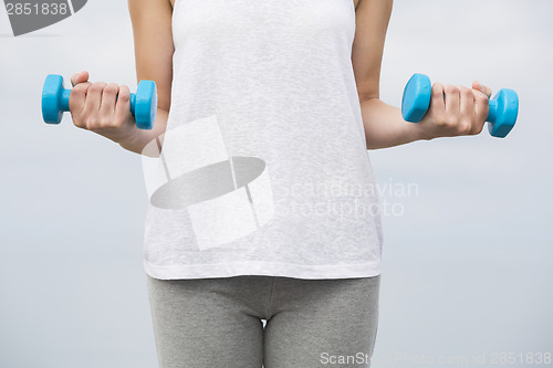 Image of Woman doing exercises with weights 