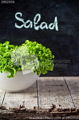 Image of lettuce salad in a bowl and blackboard 