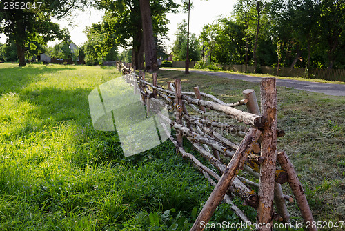 Image of rural style twisted fence of branches along road 