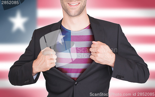 Image of Businessman opening suit to reveal shirt with flag