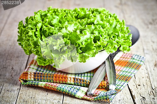 Image of lettuce salad in a bowl and spoons 