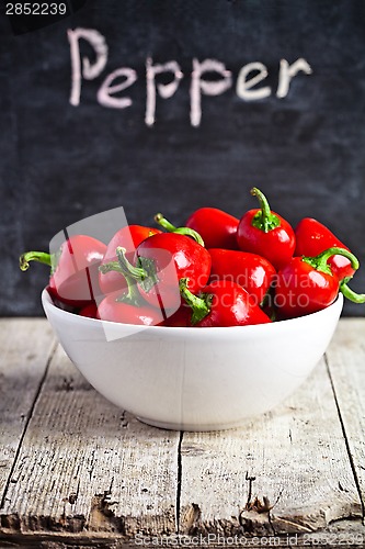 Image of red hot peppers in bowl and blackboard 