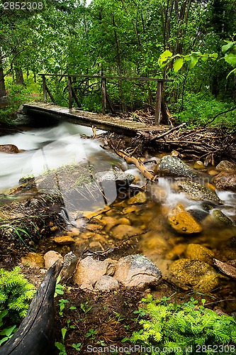 Image of walking bridge over flowing stream