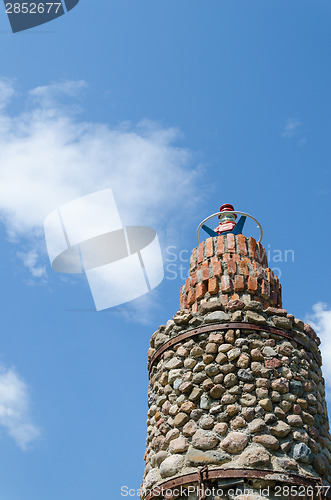 Image of cobblestone lighthouse tower blue sky background 