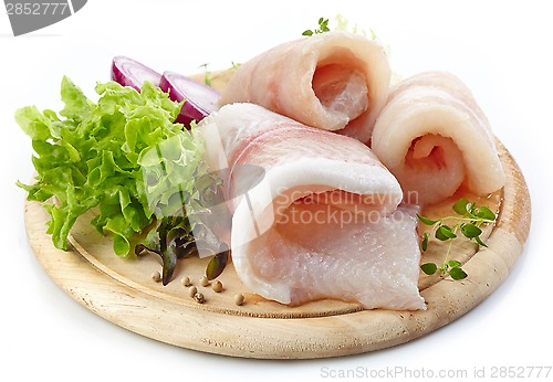 Image of raw fish fillets on wooden cutting board