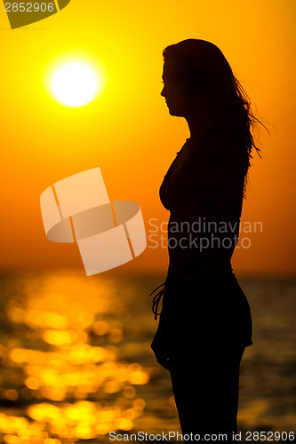 Image of Young woman silhouette at sunset