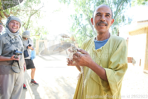 Image of Man holding desert monitor in Tozeur Zoo