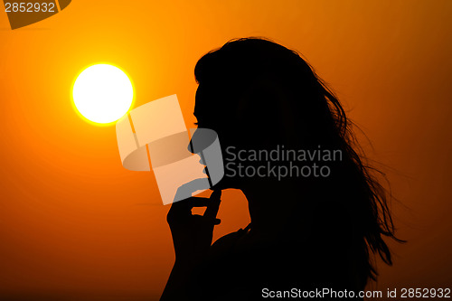 Image of Woman enjoying sunset