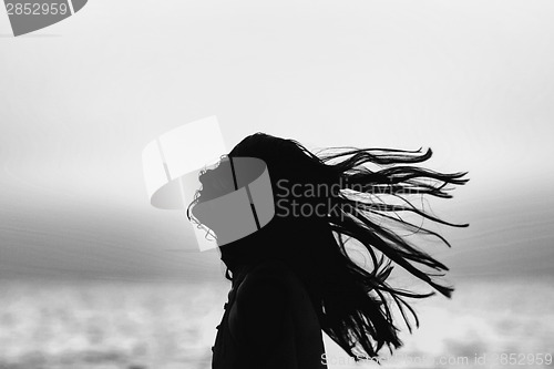 Image of Abstract of woman tossing hair at sunset black and white