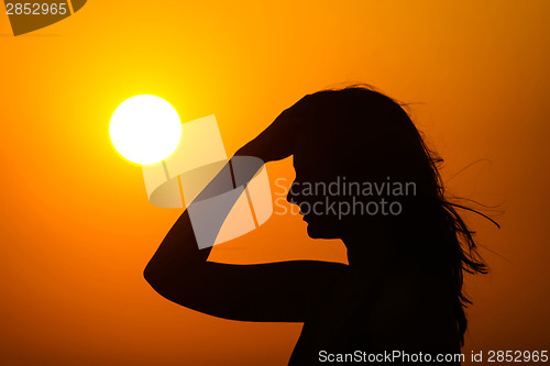 Image of Woman enjoying sunset