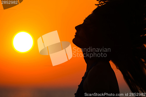 Image of Young woman at sunset