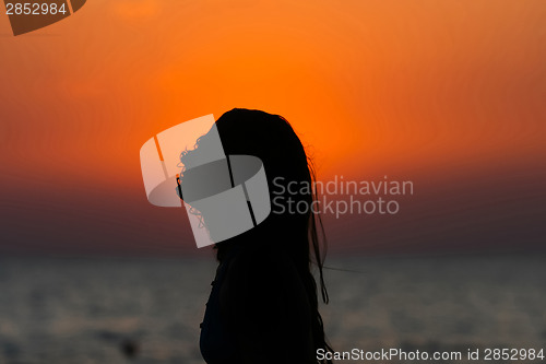 Image of Young woman at sunset with hair on her face