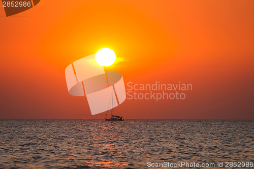 Image of Boat sailing at sunset on open sea