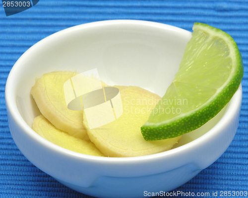 Image of Ginger with lemon in a bowl of chinaware on blue