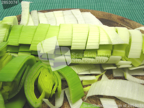 Image of SLiced green leek on a wooden plate