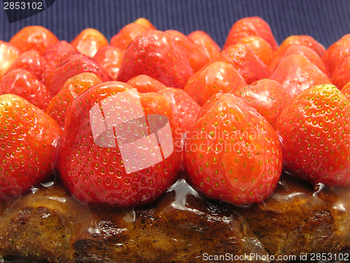 Image of Lateral close-up view of a strawberry cake on blue background