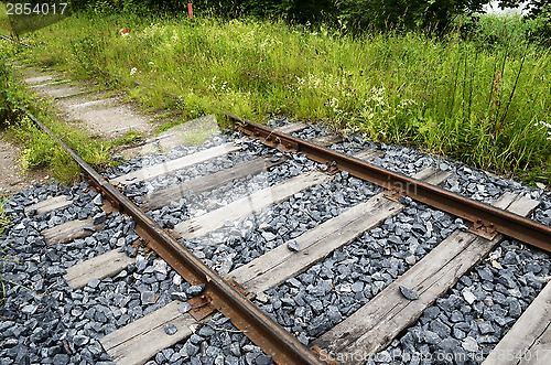 Image of old rusty rails, sleepers and grass