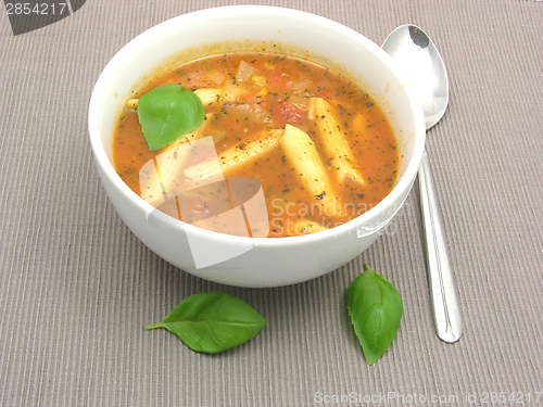 Image of Noodle soup with tomatoes and herbs on gray