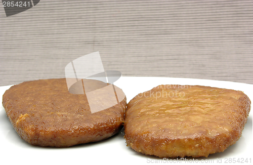 Image of Two breaded bean curd cutlets on a white plate