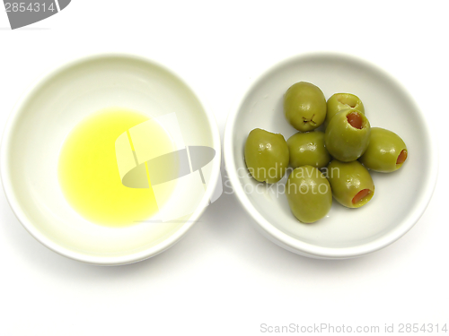 Image of Two bowls of chinaware with olive oil and olives on white background