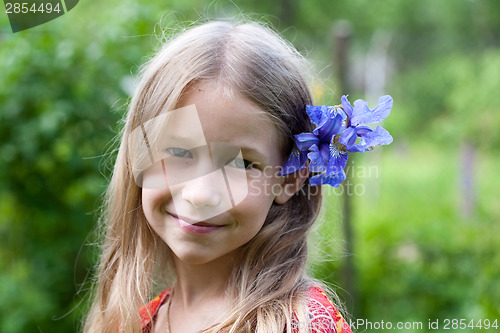 Image of small girl with blue iris flower in her hair