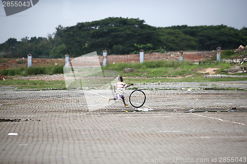 Image of African boy plays with a tire