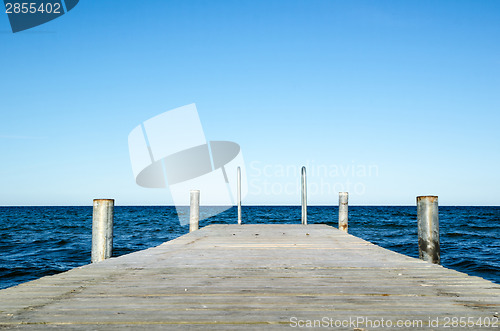 Image of Low angle image of a wooden bath pier in blue water