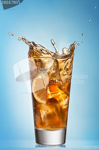 Image of Glass of splashing iced tea with lemon