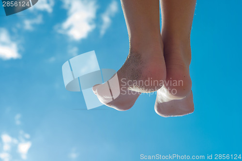 Image of Children's feet against the blue sky